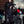 Man wearing black motorcycle jacket and jeans standing next to a black motorcycle
