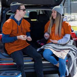 Man and woman wearing Hothands orange jerseys sitting in the back of a car