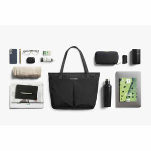 Bellroy black tote bag surrounded by organized daily essentials including a laptop, water bottle, and personal items