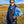 Person wearing a black Venture Heat vest over a blue hoodie in a grassy field
