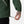 Close up of a person adjusting the drawstring hem on a dark green jacket