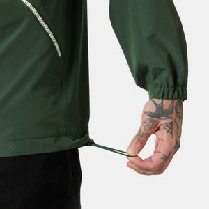 Close up of a person adjusting the drawstring hem on a dark green jacket