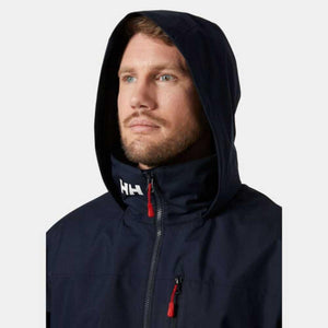 Man wearing a navy Helly Hansen hooded jacket with red zipper pulls
