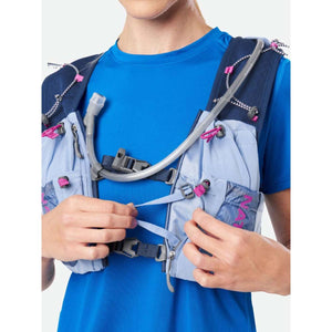 Person wearing a light blue and navy hydration vest with a drinking tube