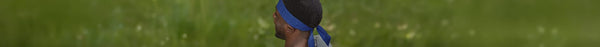 Side profile of a person with dark skin wearing a blue and white du-rag with 