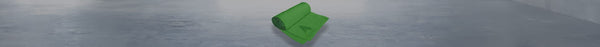 A bright green roll of fabric lies partially unrolled on a textured gray surface.