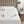 Waterproof mattress protector on a bed with a spilled glass of water and two remote controls