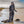 Woman wearing camouflage hunting gear standing in shallow water with duck decoys