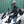 Person wearing a Simpson Racing jacket and helmet sitting on a white Honda PCX scooter