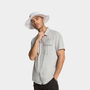 Man wearing a white bucket hat and a light grey short sleeve button down shirt