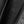Close up of the word Racer perforated in black fabric next to a zipper