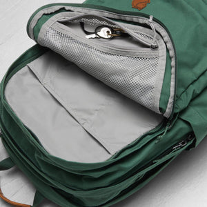 Open green Fjallraven backpack showing interior mesh pocket with keys and storage compartments