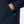Close up of navy blue jacket pocket with zipper and striped cuff detail