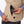 Hand placing a Mobile Warming battery pack into the zippered pocket of a tan fleece vest