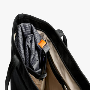 Interior view of a black Bellroy tote bag with a folded patterned pouch inside