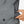 Hand placing a black Venture Heat battery pack into the pocket of a grey hooded sweatshirt