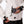 Person placing a black power bank into the zippered pocket of a white patterned heated ski jacket