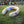 White wearable neck fan with blue and orange cooling plates on grass field with soccer players in background