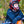 Person wearing ActionHeat black long sleeve shirt and gloves with a red motocross helmet leaning on a motorcycle