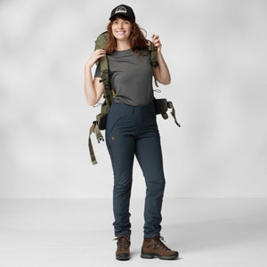 Woman wearing FjallRaven trekking trousers and backpack with hiking boots and cap
