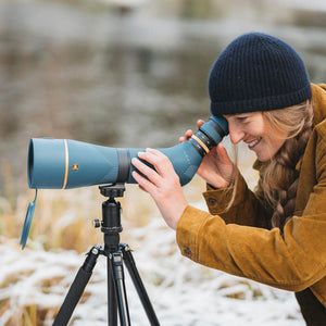 Person using a Nocs Provisions blue spotting scope on a tripod