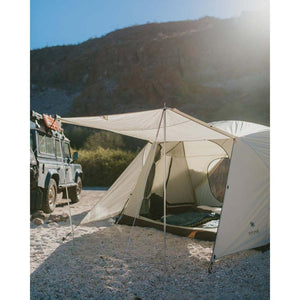 Snow Peak tent set up on a gravel campsite with an off-road vehicle parked nearby
