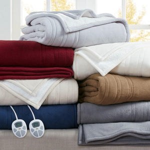 Stack of folded Serta electric blankets in various colors with two digital controllers