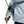 Black Diamond belay device attached to a climbing rope and carabiner on a light blue jacket