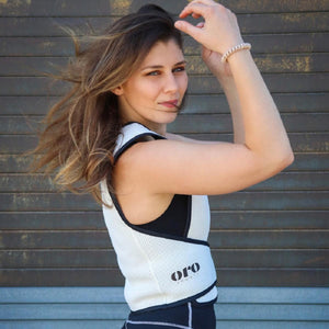 Woman wearing a white Oro Sports mesh vest over a black top