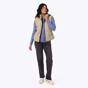 Model wearing a Mobile Warming beige fleece vest over a blue long sleeve shirt and black jeans