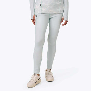 Model wearing light blue Reebok leggings and matching long sleeve top with white sneakers
