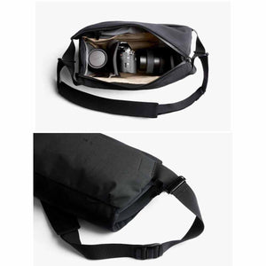 Bellroy black camera sling bag with internal dividers holding a camera and lenses