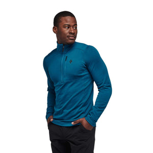 Man wearing a blue Black Diamond long sleeve quarter zip shirt