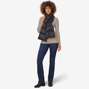 Woman wearing a black Venture Heat heated scarf over a beige long sleeve shirt and blue jeans