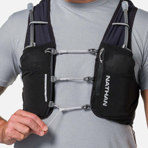 Person wearing a black Nathan hydration vest with front pockets and adjustable chest straps