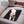 Small curly dog lying on a black polar fleece pet mat on a car seat