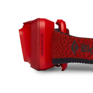 Side view of a red Black Diamond rechargeable headlamp with elastic strap