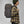 Person wearing a grey FjallRaven backpack with leather trim and a plaid shirt