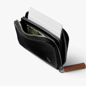 Bellroy black leather zippered wallet containing cards and paper currency
