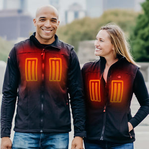 Man and woman wearing ActionHeat black heated vests with glowing orange heating elements on the chest