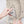 Hand placing a smartphone into the side zipper pocket of a beige backpack
