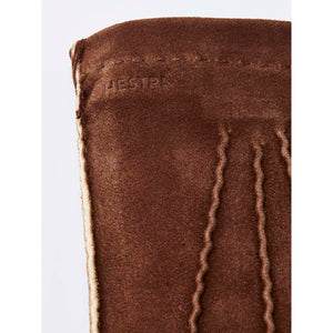 Brown suede Hestra glove detail with embossed logo