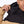 Close up of a person adjusting the hood of a tan and black Mobile Warming jacket