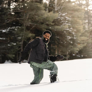 Person wearing Baffin winter boots and outdoor gear walking through deep snow