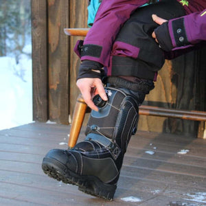 Person adjusting the BOA dial on a black DSG Outerwear snow boot