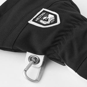 Black Hestra glove with brand logo patch and metal carabiner attachment