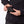 Person holding a black Mobile Warming battery pack near a jacket pocket