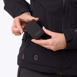 Person holding a black Mobile Warming battery pack near a jacket pocket