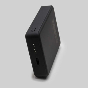 Black portable power bank with four LED battery indicator lights and a USB port