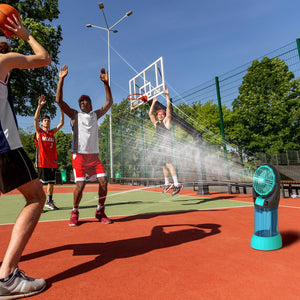 Portable misting fan on a basketball court with players in the background
